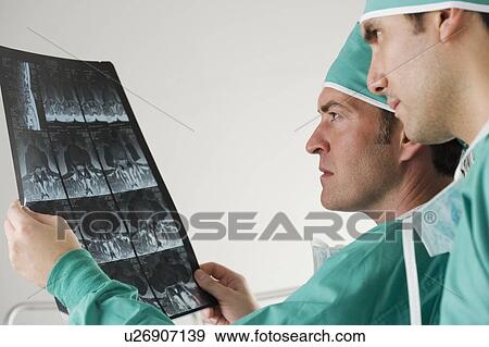 Doctors looking at x-rays View Large Photo Image Stock Photo - Doctors looking at x-rays. Fotosearch