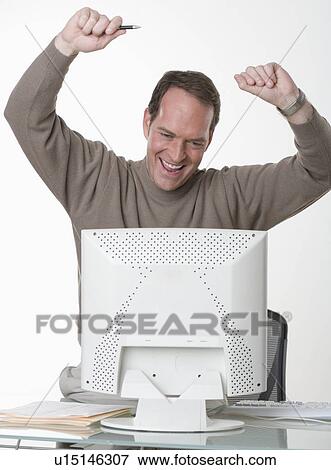 Stock Photo - Exuberant man at his computer. Fotosearch