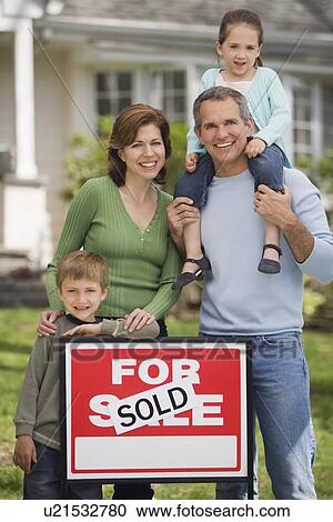 Family in front of house with For Sale/Sold sign View Large Photo Image Stock Image - Family in front of house with For Sale/Sold sign. Fotosearch