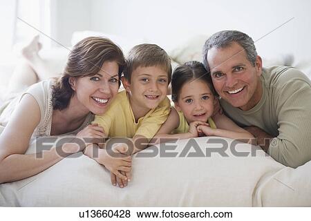 Stock Photo - Family lying on bed. Fotosearch