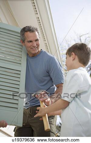 Father and young son fixing shutters View Large Photo Image Stock Photograph - Father and young son fixing shutters. Fotosearch