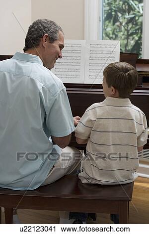 Father and young son playing piano View Large Photo Image Stock Image - Father and young son playing piano. Fotosearch