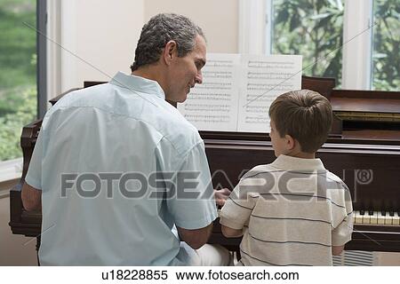 Father and young son playing piano View Large Photo Image Stock Photography - Father and young son playing piano. Fotosearch