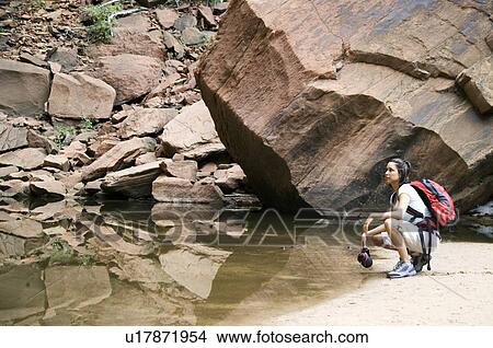 Picture - Female backpacker relaxing at a mountain lake. Fotosearch