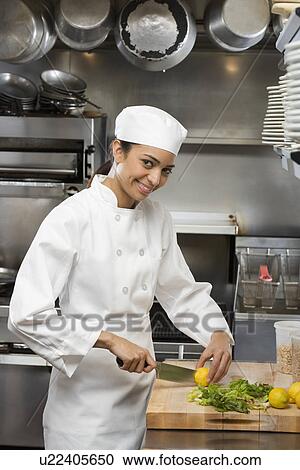 Stock Image - Female chef in restaurant kitchen. Fotosearch