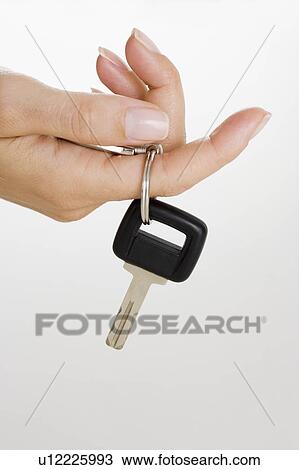 Stock Image - Female hand holding car key. Fotosearch