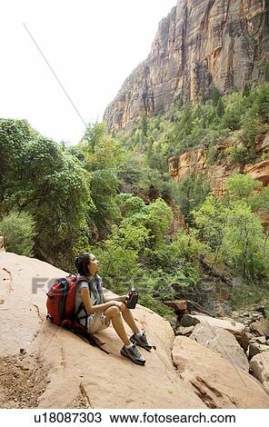 Female hiker resting on a rock View Large Photo Image Stock Image - Female hiker resting on a rock. Fotosearch