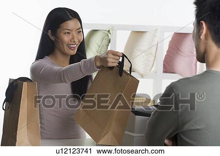 Stock Image - Female sales person assisting customer. Fotosearch
