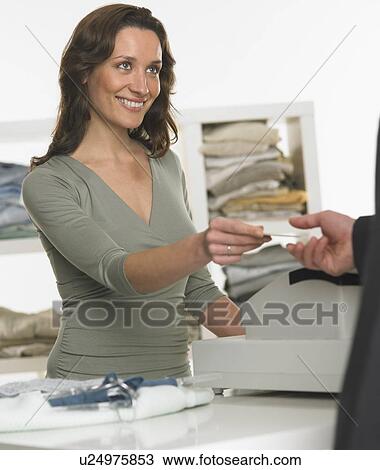 Stock Image - Female salesperson assisting male customer. Fotosearch
