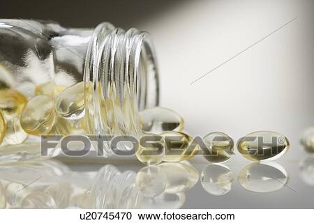 Gelcaps spilling out of glass bottle View Large Photo Image Stock Image - Gelcaps spilling out of glass bottle. Fotosearch