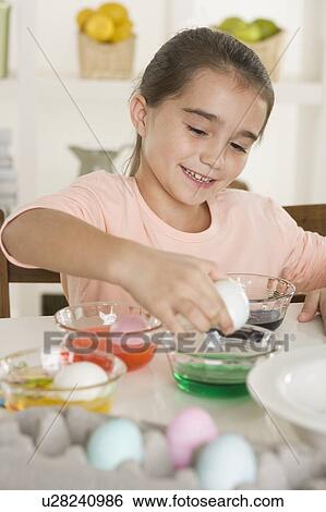 Stock Photograph - Girl coloring Easter eggs. Fotosearch