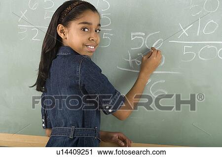 Stock Image - Girl writing on chalkboard. Fotosearch