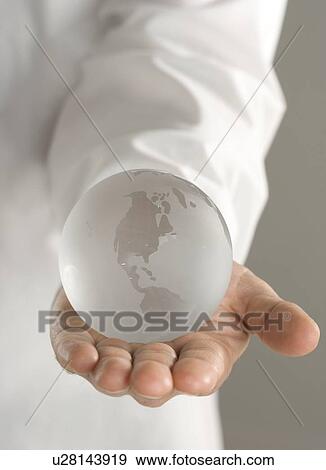 Stock Photo - Glass globe held in outstretched hand. Fotosearch