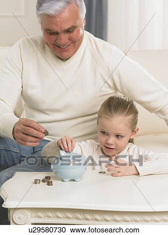 Grandfather and young granddaughter putting change in piggy bank View Large Photo Image Stock Image - Grandfather and young granddaughter putting change in piggy bank. Fotosearch