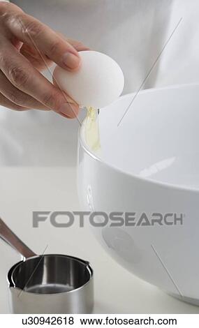 Hand cracking egg into bowl View Large Photo Image Stock Photo - Hand cracking egg into bowl. Fotosearch