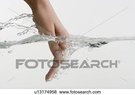 Hand dipping into water View Large Photo Image Stock Photo - Hand dipping into water. Fotosearch
