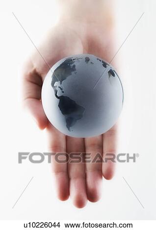 Picture - Hand holding a miniature globe. Fotosearch