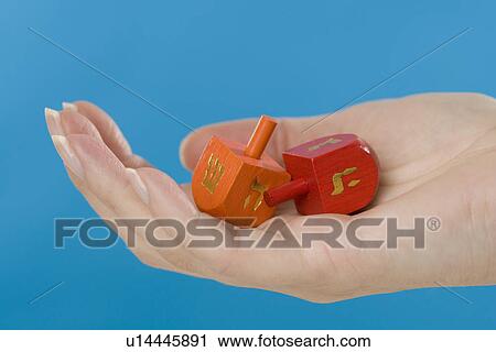 Stock Image - Hand holding Jewish Dradles. Fotosearch