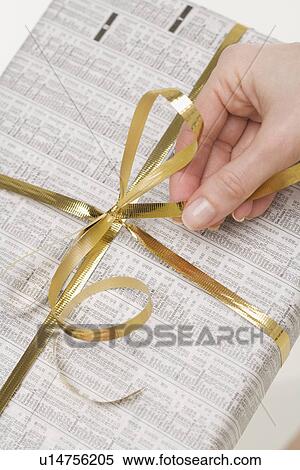 Stock Photography - Hand on bow of present. Fotosearch
