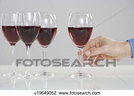 Stock Image - Hand reaching for glass of wine. Fotosearch