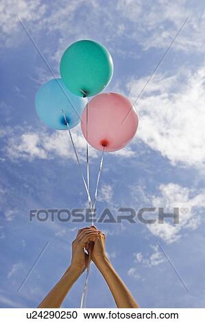 Hands holding balloons toward sky View Large Photo Image Stock Image - Hands holding balloons toward sky. Fotosearch