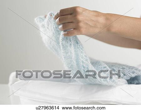 Hands lifting garment from package View Large Photo Image Picture - Hands lifting garment from package. Fotosearch