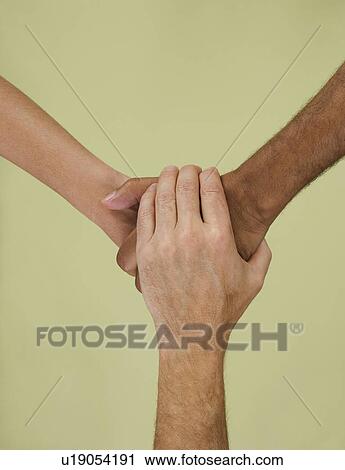 Stock Image - Holding hands in multiracial group. Fotosearch