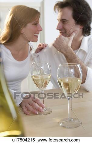 Stock Photography - Laughing couple with white wine. Fotosearch