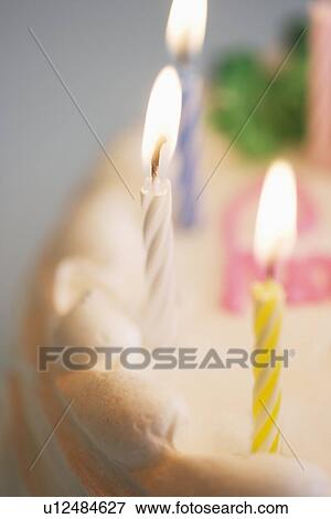 Lit candles on a birthday cake View Large Photo Image Stock Photo - Lit candles on a birthday cake. Fotosearch