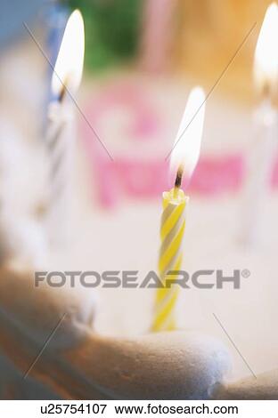Lit candles on a birthday cake View Large Photo Image Stock Photo - Lit candles on a birthday cake. Fotosearch