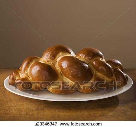 Stock Photo - Loaf of Challah bread on platter. Fotosearch