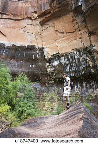 Stock Image - Male backpacker taking in the scenery. Fotosearch