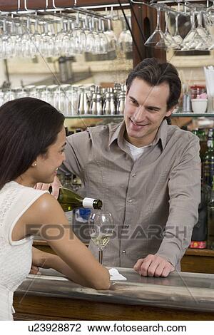 Male bartender pouring wine for female customer View Large Photo Image Stock Image - Male bartender pouring wine for female customer. Fotosearch