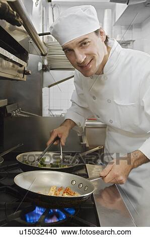 Stock Image - Male chef in restaurant kitchen. Fotosearch