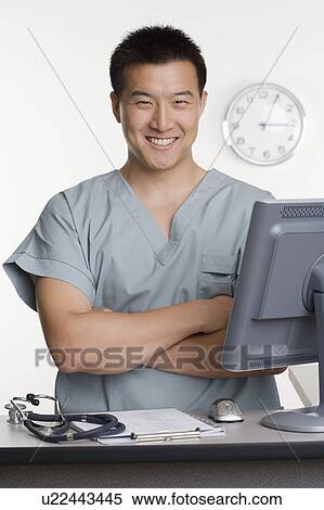 Male healthcare worker standing at desk View Large Photo Image Stock Photography - Male healthcare worker standing at desk. Fotosearch