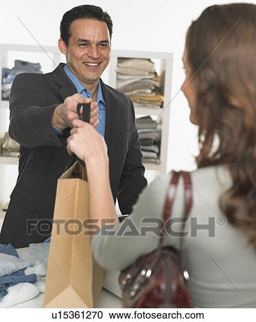Male salesperson assisting female customer View Large Photo Image Stock Image - Male salesperson assisting female customer. Fotosearch