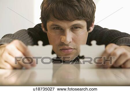 Man connecting puzzle pieces View Large Photo Image Stock Photo - Man connecting puzzle pieces. Fotosearch