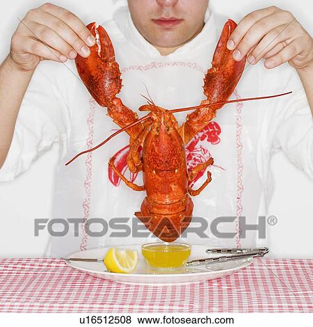 Man dining with an entire lobster View Large Photo Image Stock Photo - Man dining with an entire lobster. Fotosearch