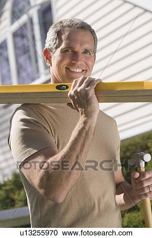 Man holding tools and wood outdoors View Large Photo Image Stock Image - Man holding tools and wood outdoors. Fotosearch