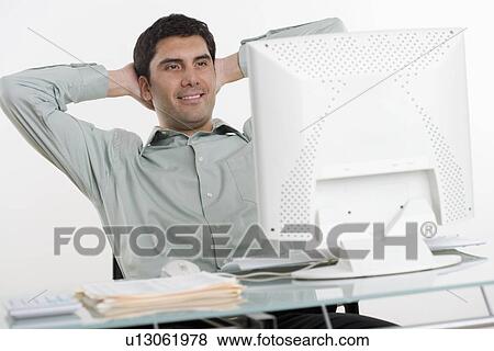 Stock Photo - Man looking at his computer. Fotosearch