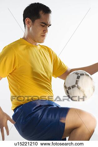 Stock Image - Man playing with soccer ball. Fotosearch