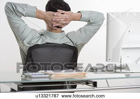 Man relaxing at his desk View Large Photo Image Stock Photo - Man relaxing at his desk. Fotosearch