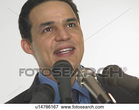 Man speaking into microphones View Large Photo Image Stock Photo - Man speaking into microphones. Fotosearch