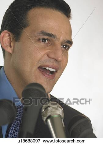 Man speaking into microphones View Large Photo Image Stock Photo - Man speaking into microphones. Fotosearch