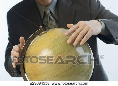 Stock Photo - Man spinning a globe. Fotosearch