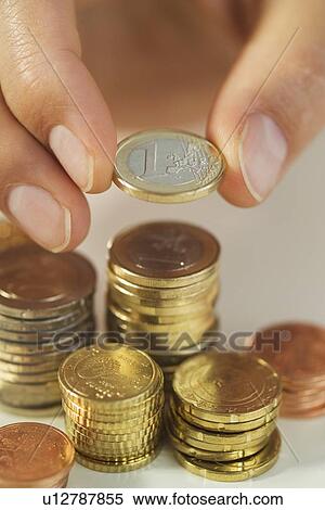 Stock Photography - Man stacking Euro coins. Fotosearch