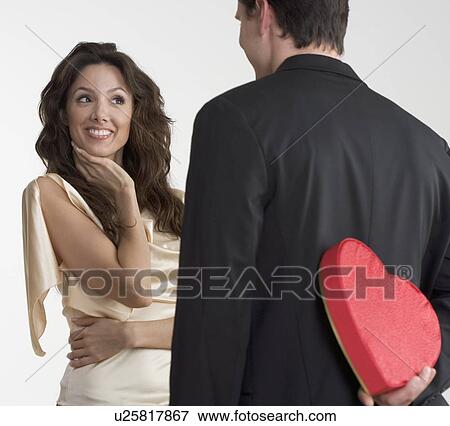 Man surprising woman with valentine View Large Photo Image Stock Photo - Man surprising woman with valentine. Fotosearch