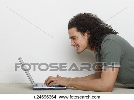 Picture - Man using a laptop computer. Fotosearch