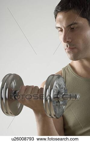 Stock Image - Man using free weights. Fotosearch