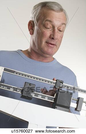 Man weighing himself View Large Photo Image Stock Photo - Man weighing himself. Fotosearch